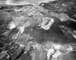 Pearl Harbor im Oktober 1941; in der Mitte Ford Island, links davon die Liegeplätze der Schlachtschiffe, die so genannte Battleship Row (Schlachtschiff-Allee), By USN [Public domain], via Wikimedia Commons