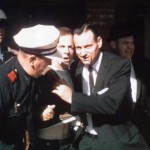 Der festgenommene Lee Harvey Oswald wird aus dem Texas Theatre abgeführt. Gemeinfrei, via Wikimedia Commons