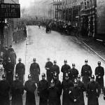 Tonypandy-Aufstand, Polizeiblockade während der Unruhen. Als Tonypandy-Aufstand werden die Unruhen im südlichen Wales im Jahr 1910 bezeichnet, die sich aus einem Bergarbeiterstreik nahe der walisischen Stadt Tonypandy entwickelten.. See page for author [Public domain], via Wikimedia Commons