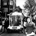 Verkehrsminister Irene Vorrink macht die erste Fahrt mit dem elektrisch betriebenen "Witkar" an der Prinsengracht in Amsterdam (21.März 1974). Collectie SPAARNESTAD PHOTO/NA/Anefo/Fotograaf onbekend[dead link] [CC BY-SA 3.0 nl], via Wikimedia Commons