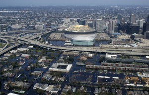 Hurrikan Katrina: Der beschädigte Superdome inmitten des überfluteten New Orleans. By Jeremy L. Grisham (U.S. Navy) [Public domain], via Wikimedia Commons