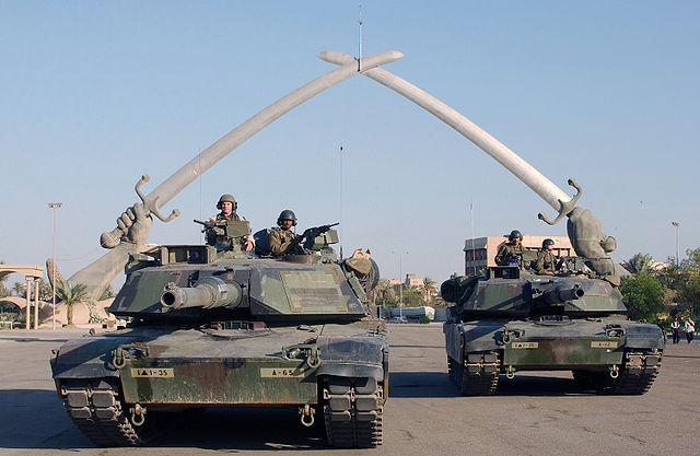 Zweiter Irakkrieg: M1A1-Abrams-Kampfpanzer vor dem Triumphbogen Hands of Victory (Schwerter von Kadesia) in Bagdad. By English: Technical Sergeant John L. Houghton, Jr., United States Air Force (http://arcweb.archives.gov/) [Public domain], via Wikimedia Commons