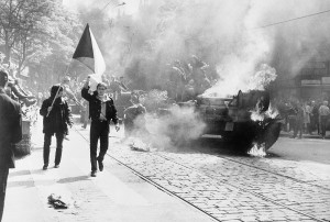 Einwohner von Prag mit tschechoslowakischer Flagge vor einem sowjetischen Panzer - By The Central Intelligence Agency (10 Soviet Invasion of Czechoslovakia) [Public domain], via Wikimedia Commons