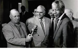 Basil Coronakis, Herausgeber von New Europe (links), interviewt Nelson Mandela in Johannesburg. Dies war eines der ersten Interviews, das Mandela 1990, 27 Jahre nach seiner Inhaftierung, gab. - https://www.flickr.com/photos/abkor/26673933865/ [Public domain]